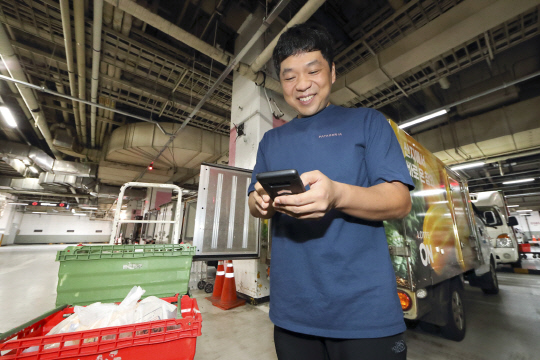 KT가 롯데온과 손잡고 전국 롯데마트에 디지털 물류 솔루션을 적용한다. 사진은 롯데마트 배송기사가 AI 운송 최적화 플랫폼을 활용하는 모습.  KT 제공